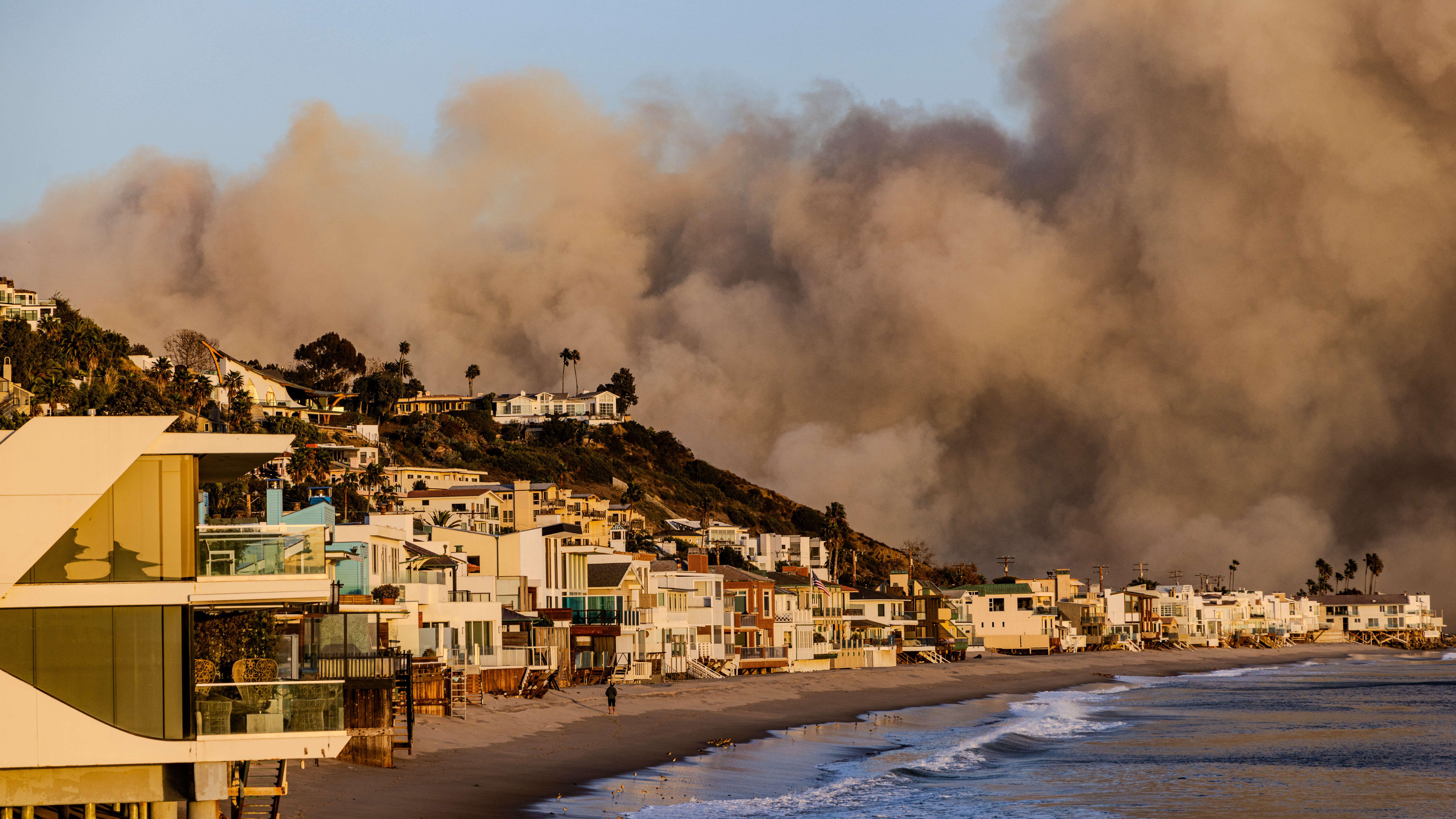 Malibu, California, USA. 7th Jan, 2025. Smoke billowing from the Palisades Fire behind the exclusive Malibu beach community that houses many movie stars and other celebrities. The fire broke out as seen from the PCH (Pacific Coast Highway) in the affluent