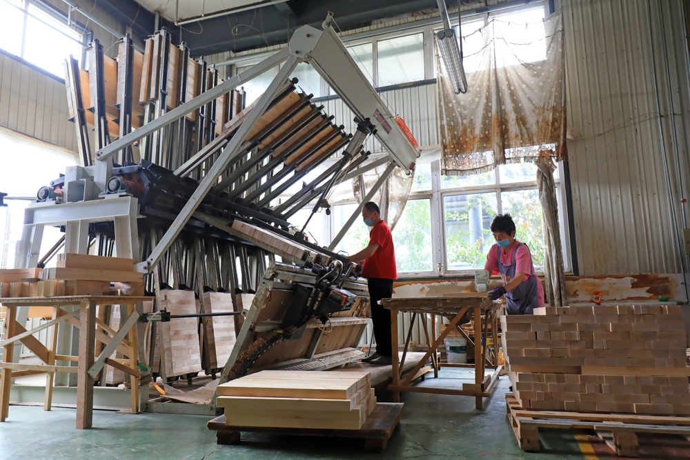 Huge volumes of wooden furniture—sold extensively through retail outlets across the United States—are manufactured in China, the world's largest producer of manufactured wooden products...this includes Luannan County in China, where workers work hard on the furniture production line. (Photo Credit: Asset id: 2162807637 via Shutterstock Images)